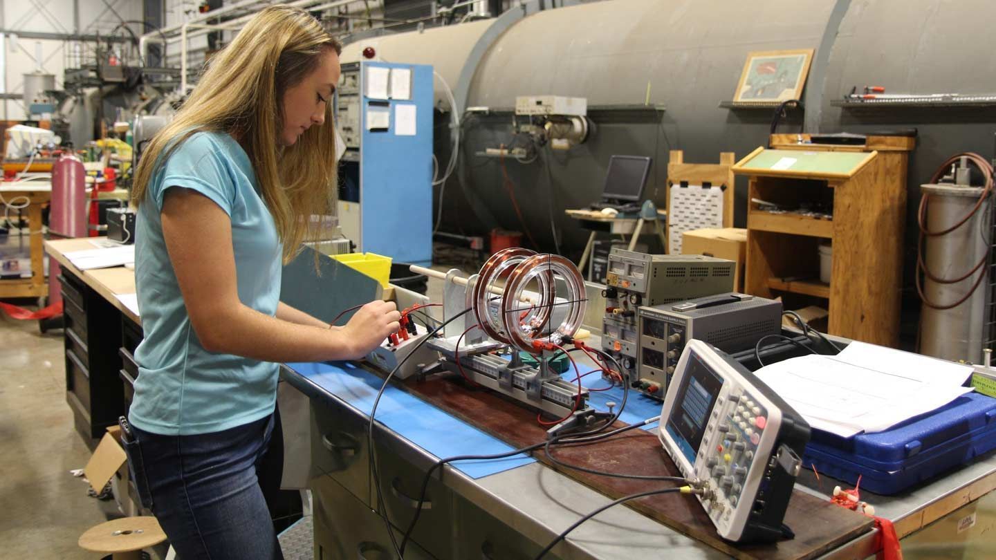 A yound woman college student conducts research in an engineering lab at UAH
